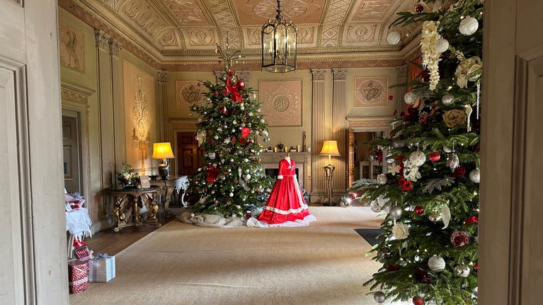 View through two doors to a Christmas tree with a santa dress displayed in front
